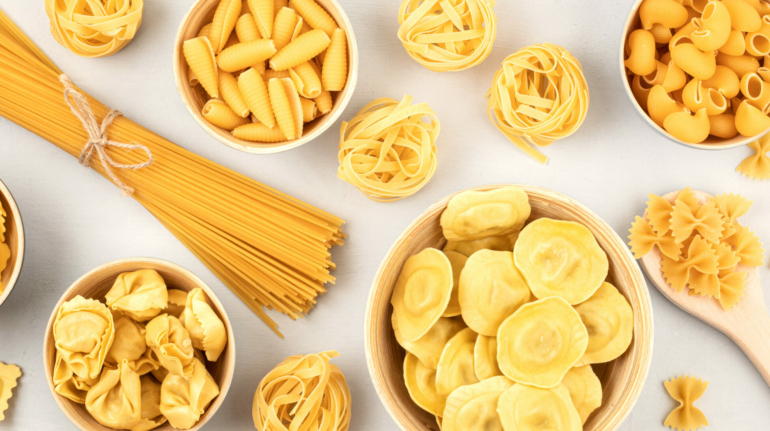 Flat lay with different types of traditional italian pasta. Penne, tagliatelle, fusilli, farfalle, spaghetti and others. Traditional italian cusine concept. Top view